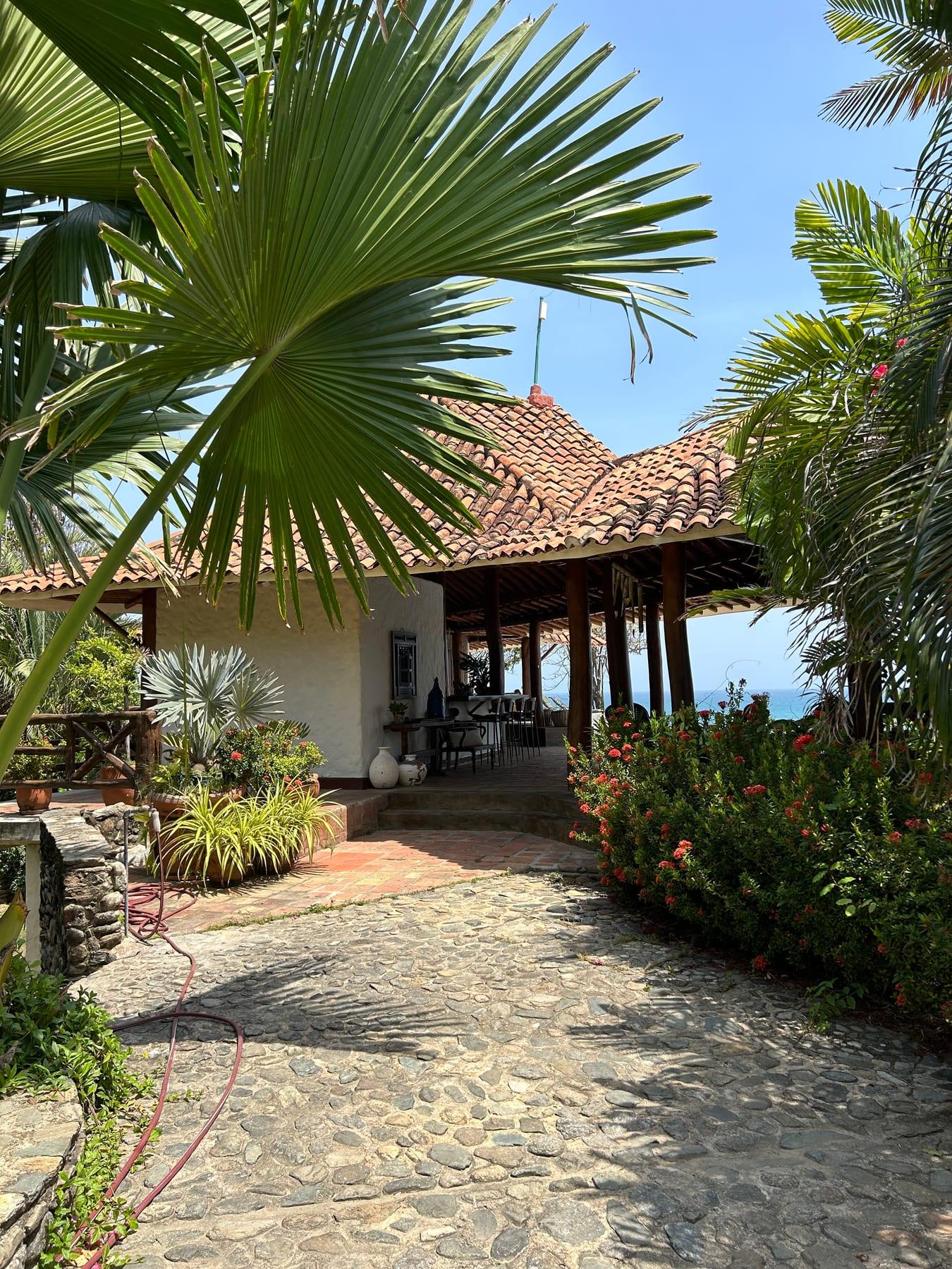 Entrada empedrada y corredor de Casa Mar, con el mar al fondo